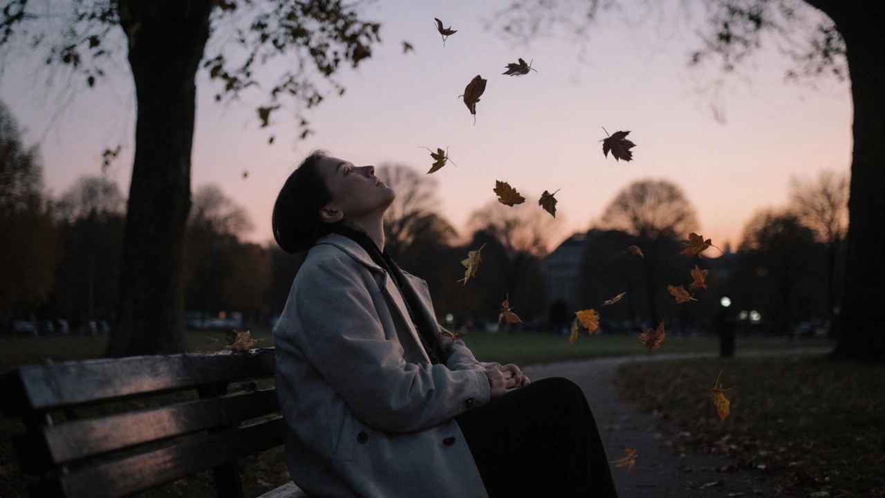 A person sitting peacefully on a park bench at twilight, experiencing quiet emotional release.
