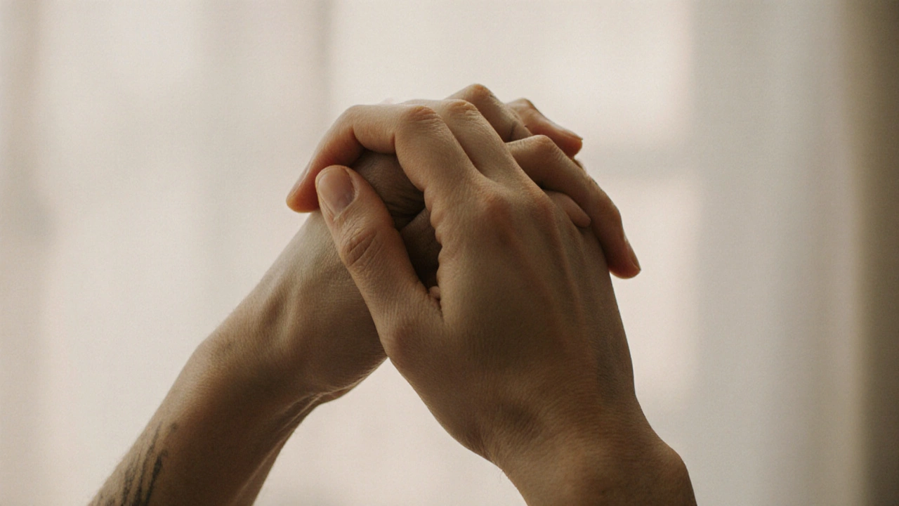 Two hands gently holding each other in a quiet, intimate moment.