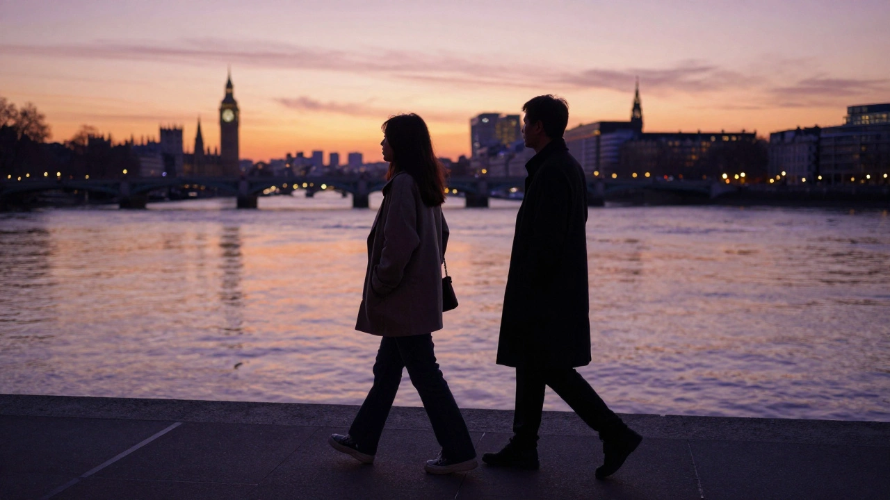 Two individuals walking calmly along the Thames at sunset, side by side in silent companionship.