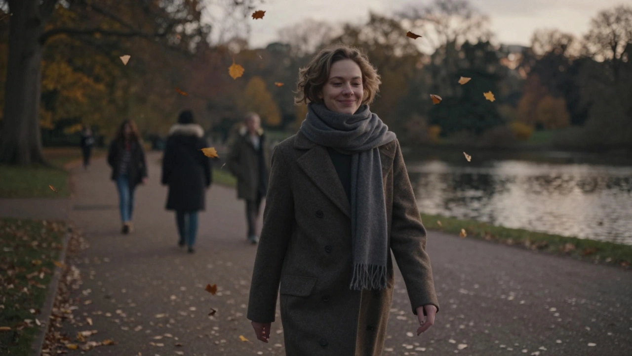 A person walking peacefully through Hyde Park at dusk, surrounded by falling autumn leaves.